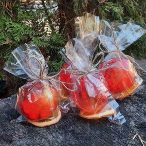 Four handcrafted tea spheres with vibrant colors, elegantly displayed on a rustic wooden stump.