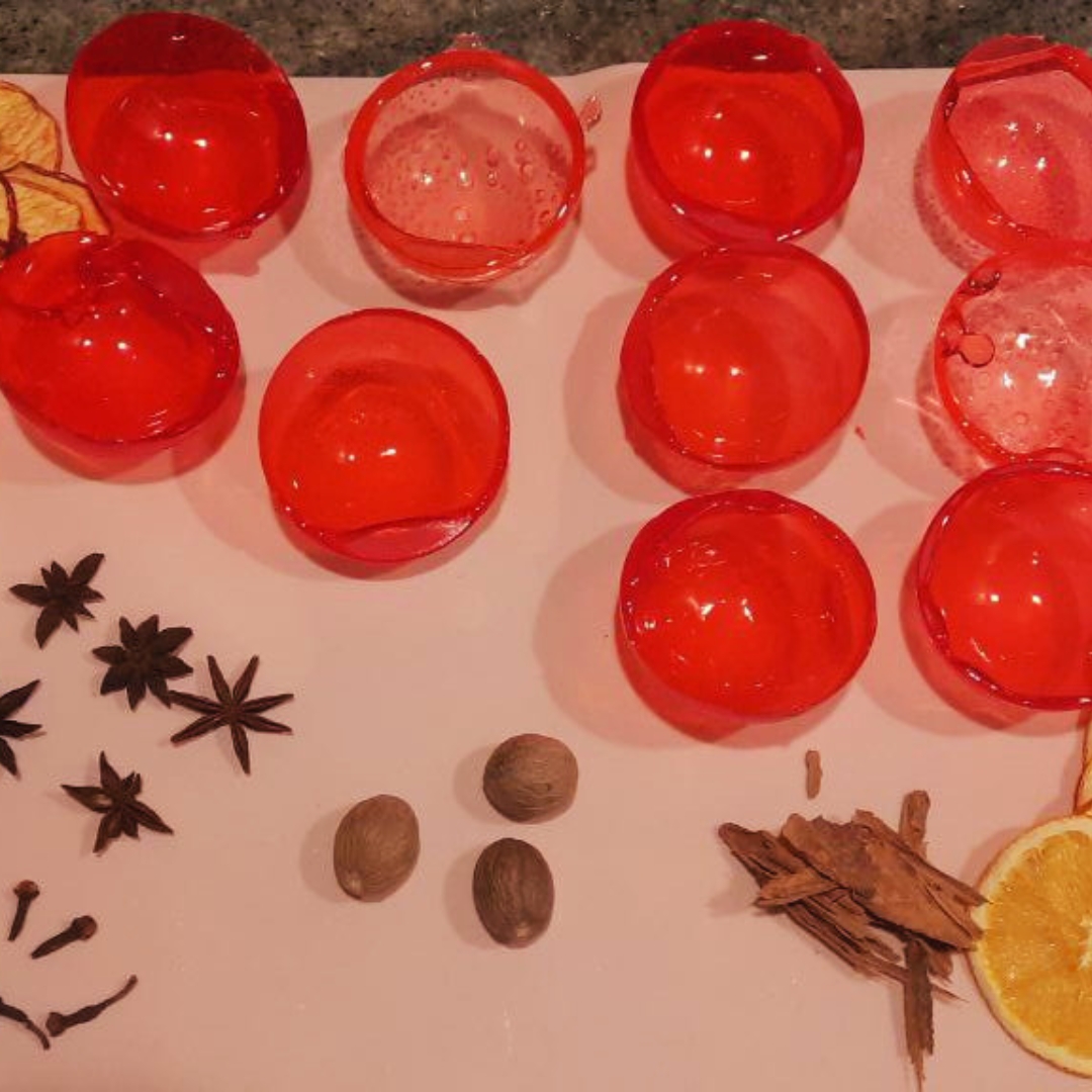 Bright red handcrafted tea spheres elegantly arranged with festive holiday decor